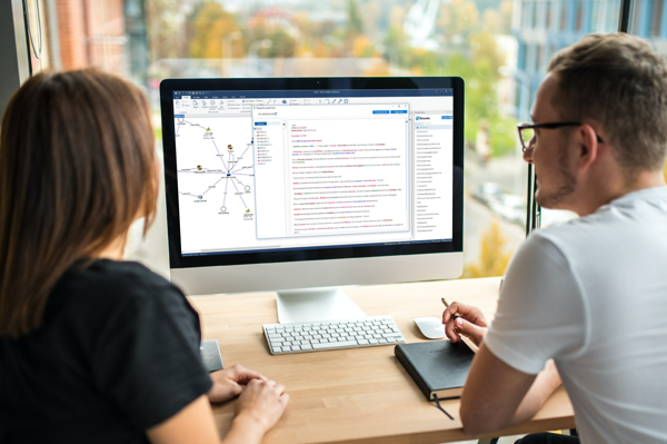 Two people at a computer with i2 TextChart on the screen.